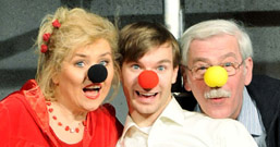 Foto: 3 Kabarettisten mit Clownsnasen in Schwarz, Rot und Gelb