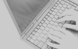 monochromes, graues Foto: Hände auf der Tastatur eines Laptops