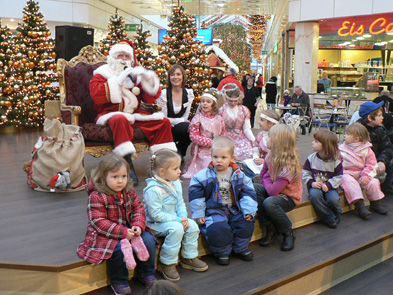 Foto: sitzender Weihnachtsmann auf der Bühne mit Kindern
