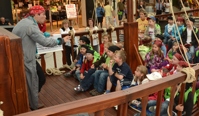Foto: Pirat erzählt sitzenden Kindern eine Geschichte.
