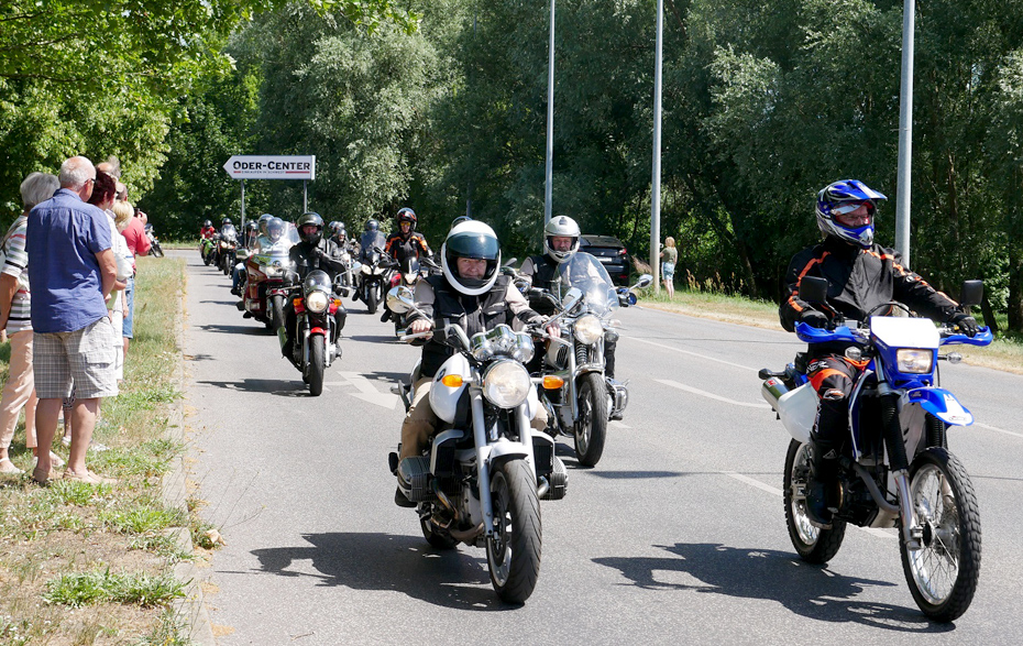 Foto: Motorradkolonne und Zuschauer am Straßenrand