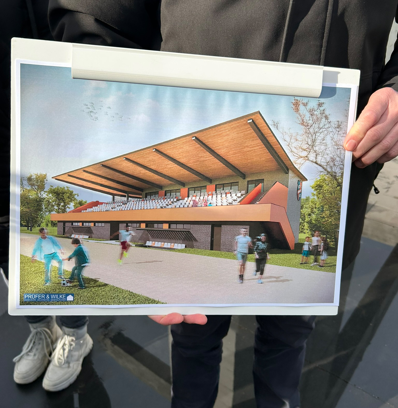 Foto: Eine Grafik mit der geplanten Tribüne wird gezeigt.