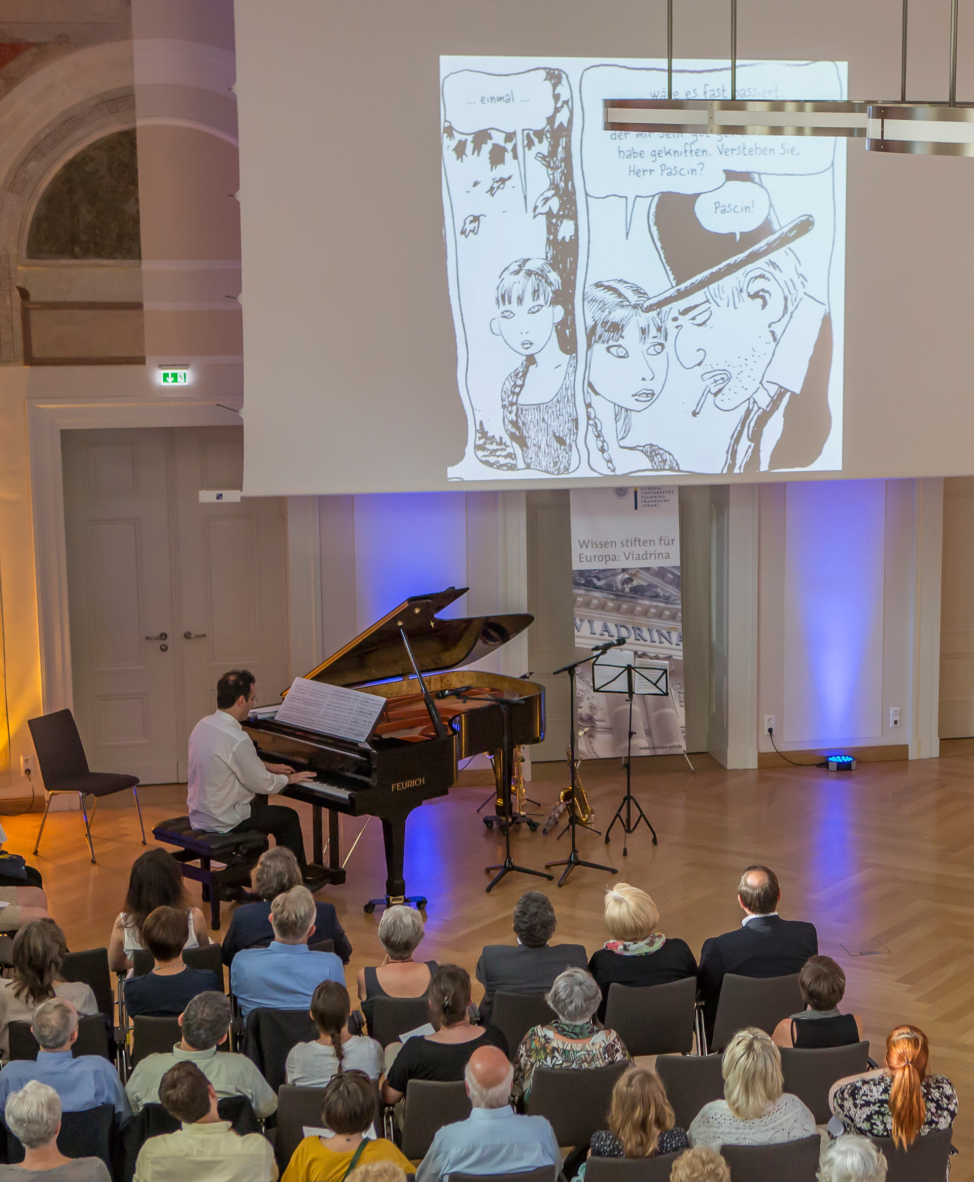 Foto: Pianist mit Publikum und Leinwand