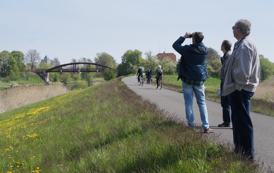 Foto: Mann mit Fernglas, Wandernde und Radfahrende