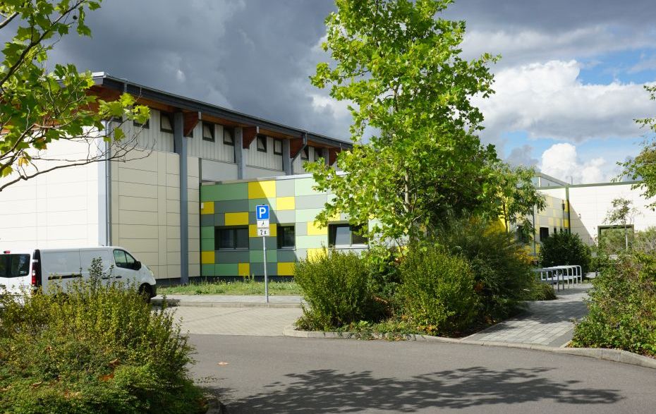 Foto: Sporthallen-Fassade in Beige, Grün, Gelb und Grau