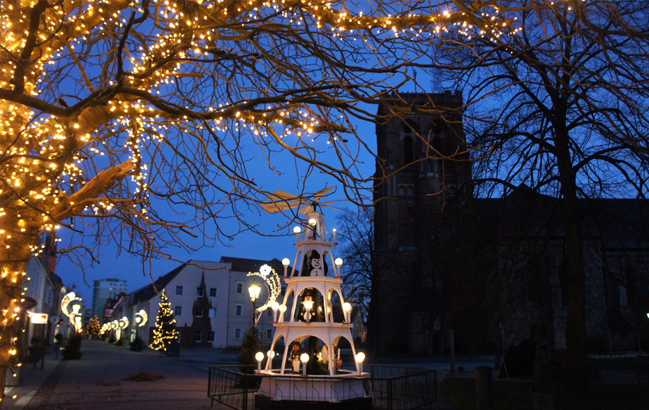 Foto: weihnachtlich beleuchtete Straße am Abend mit Pyramide und Weihnachtsbaum