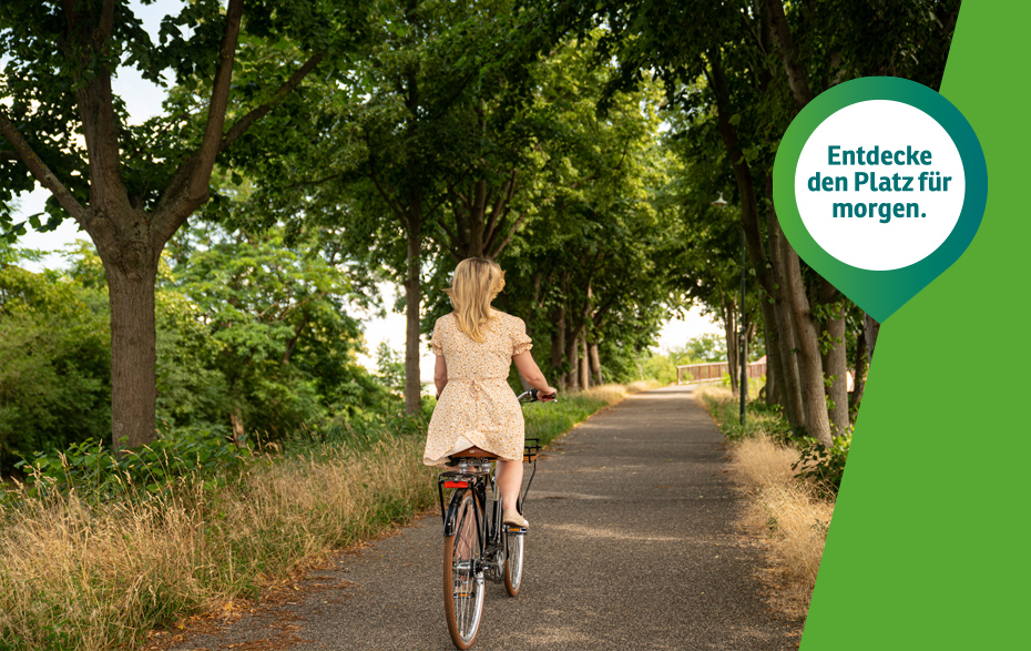 Foto: Radfahrerin von hinten auf einem Weg mit Bäumen rechts und links Und der grüne Pin „Entdecke den Platz für morgen.“