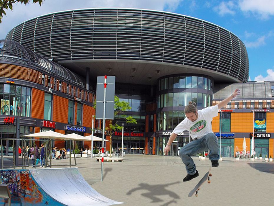 Mann auf Skateboard auf Platz in der Stadtmitte