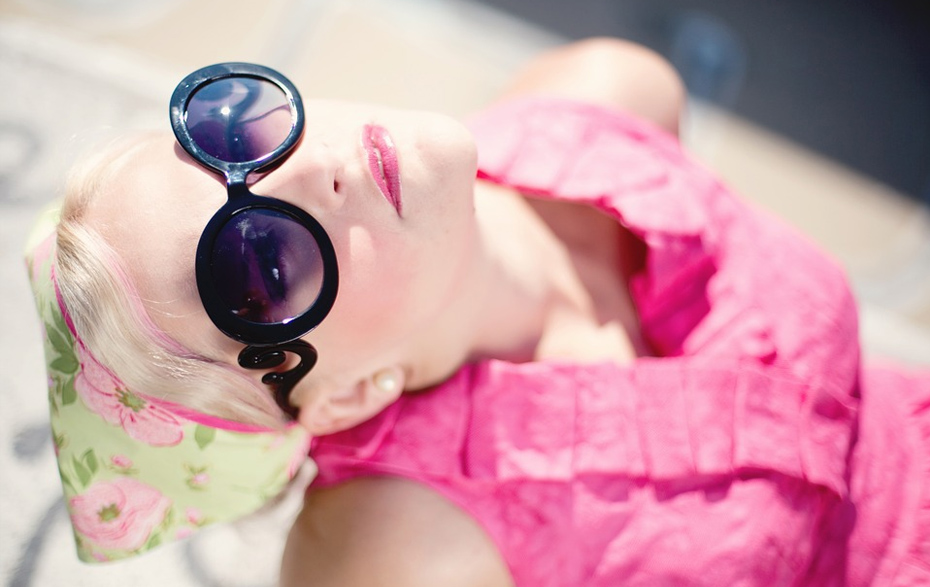 Foto: Frau mit Sonnenbrille sonnt sich.