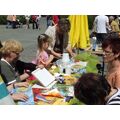 Foto: Kinder und Erwachsene sitzen an einem Tisch und basteln.