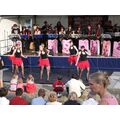 Foto: Tänzerinnen mit roten Röcken vor der Big Band