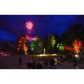 Foto: Feuerwerk über den farbig beleuchteten Parkbäumen