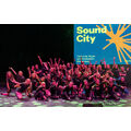 Gruppenfoto der Tanzgruppe auf der Bühne mit Sound-City-Werbung