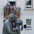 Foto: Blick durch die Plastik Liebespaar zum geschmückten Rathausbalkon
