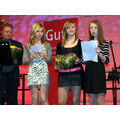 Foto: Drei Mädchen verlesen ihre Dankesworte auf der Bühne.