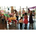 Foto: Mehrere Kinder mit Papp-Schirmen vollführen einen Tanz.