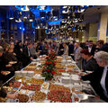 Foto: Blick auf den gefüllten Buffettisch, umringt von Personen.