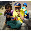 Foto: Zwei Kinder sitzen auf einem Stein und essen Eis.