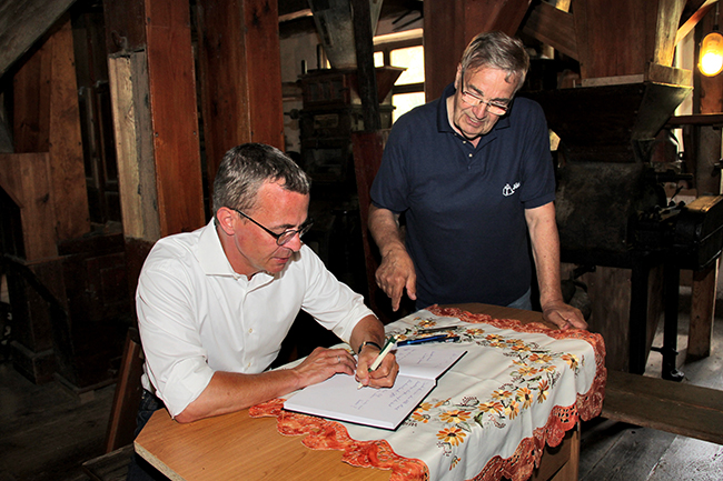 Wirtschaftsminister Albrecht Gerber trägt sich ins Gästebuch der Kanow-Mühle Sagritz ein.